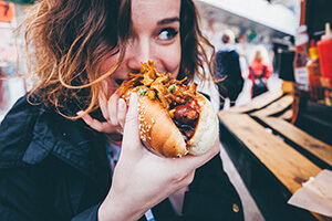 Woman eating a hot dog.